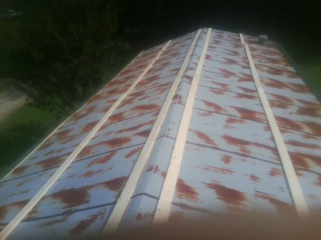 Rusted metal roof panels with new wood purlins before replacement — Storm Damage Roof Repair in Grace by Roofing Brothers