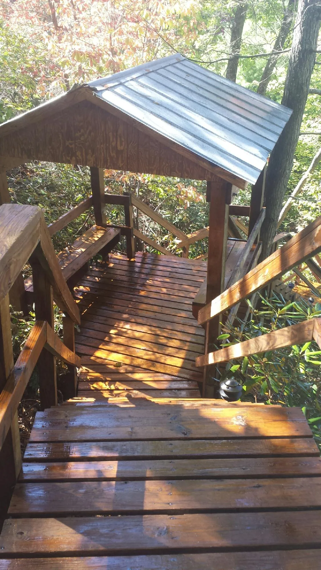 Freshly stained wood walkway and covered shelter with a metal roof in Grace