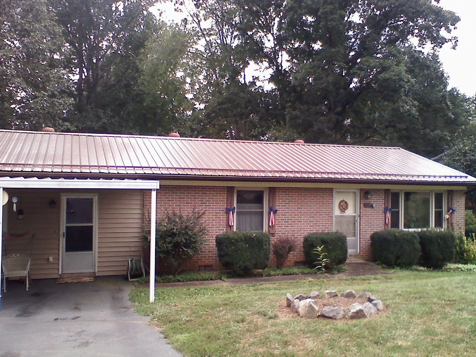 Bronze metal roof and carport on a brick ranch home — Roof Repair work by our crew in Grace