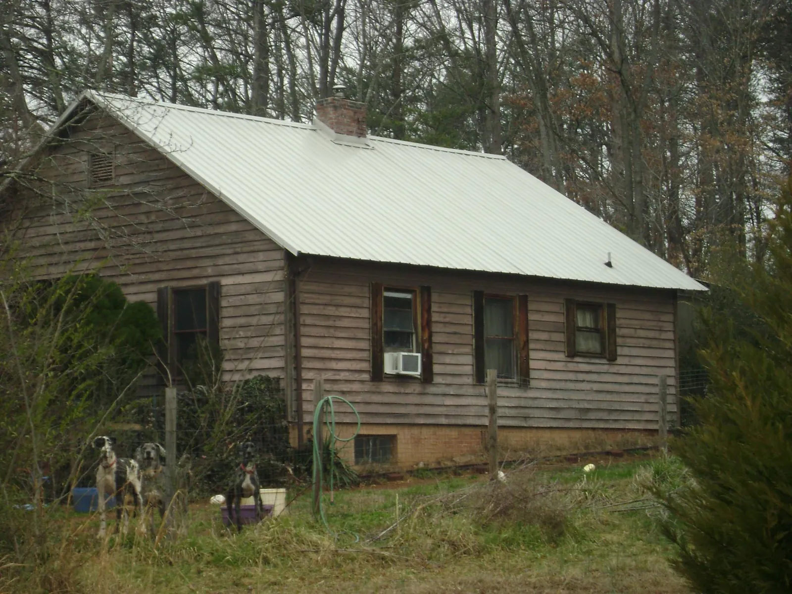 White metal roof on an old wood sided farmhouse, from a Metal Roof Installation job in Grace